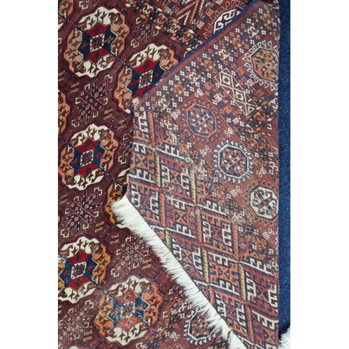 4 - A ochre ground antique Turkoman rug with all-over multicoloured lozenge patterned ground within mult... 