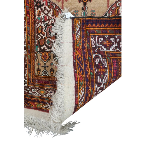15 - A beige ground eastern style prayer rug with floral patterned ground within multicoloured geometric ... 