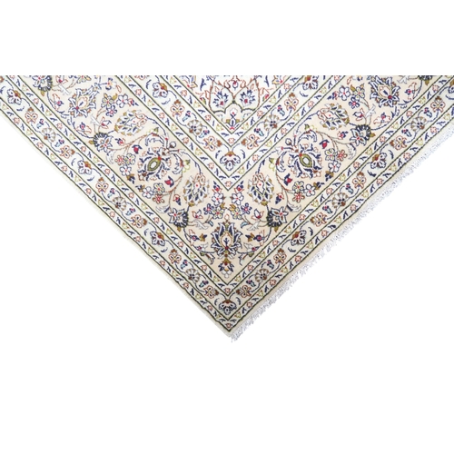 2004 - AN IVORY GROUND FINE PILE HAND WOVEN KESHAN RUG with sunburst central medallion on floral/foliate pa... 