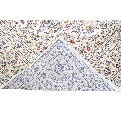 2004 - AN IVORY GROUND FINE PILE HAND WOVEN KESHAN RUG with sunburst central medallion on floral/foliate pa... 