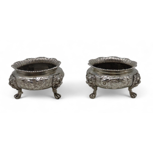 A pair of Victorian silver salts, by Daniel & Charles Houle, London 1845, of circular form, with everted gadrooned rim,s with embossed floral decoration, on three lion'smask paw handles, 338gms (2)