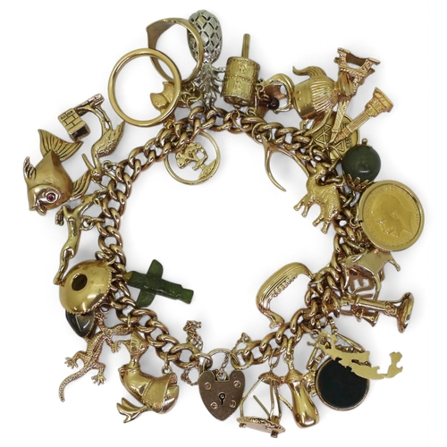 A 9ct gold curb chain bracelet, with eleven 9ct gold charms to include a large fish with gem set eyes, four 18k charms, eight 14k charms to include a lizard, six in yellow metal and a 1913 gold half sovereign, a yellow metal mounted Canadian green hardstone totem pole charm and a silver pineapple, weight all together 105gms