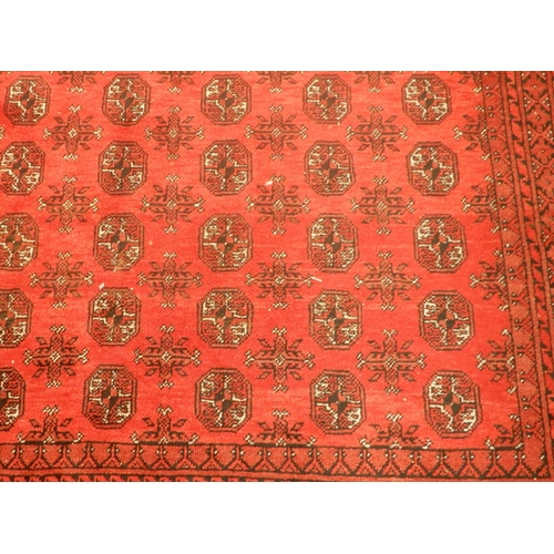 3 - A large red ground Afghan Tekke style rug with distinctive all over lozenge design within multiple d... 