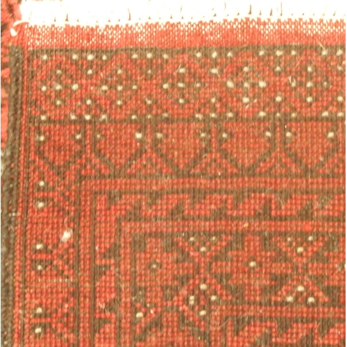 3 - A large red ground Afghan Tekke style rug with distinctive all over lozenge design within multiple d... 