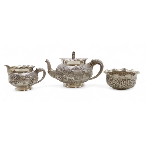 2264 - A CALCUTTA WHITE METAL TEAPOTWith matching cream jug and an associated sugar bowl, the teapot and cr... 
