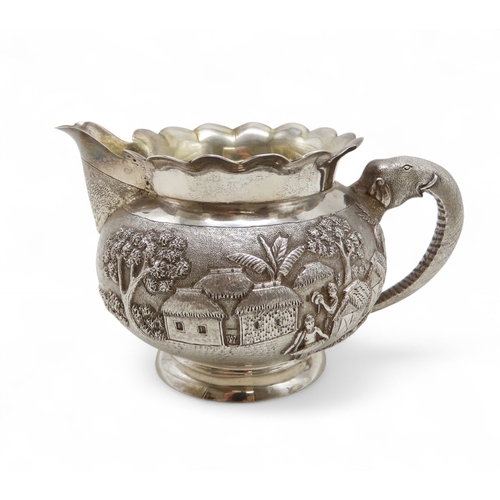 2264 - A CALCUTTA WHITE METAL TEAPOTWith matching cream jug and an associated sugar bowl, the teapot and cr... 