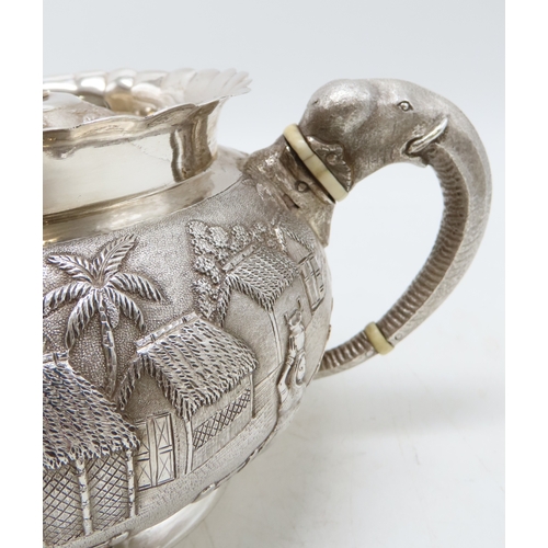 2264 - A CALCUTTA WHITE METAL TEAPOTWith matching cream jug and an associated sugar bowl, the teapot and cr... 