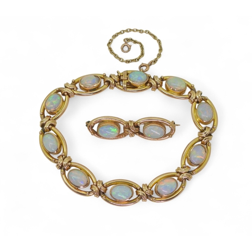 2733 - A 15CT GOLD OPAL BRACELETthe oval links are interspaced with gold knots, very lively opals, with ful... 