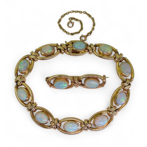 2733 - A 15CT GOLD OPAL BRACELETthe oval links are interspaced with gold knots, very lively opals, with ful... 