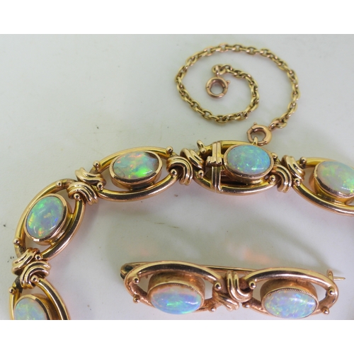 2733 - A 15CT GOLD OPAL BRACELETthe oval links are interspaced with gold knots, very lively opals, with ful... 