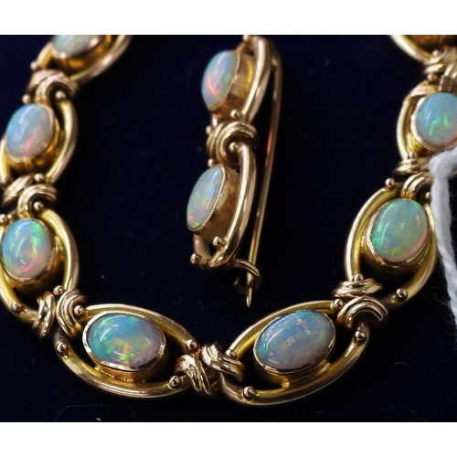 2733 - A 15CT GOLD OPAL BRACELETthe oval links are interspaced with gold knots, very lively opals, with ful... 