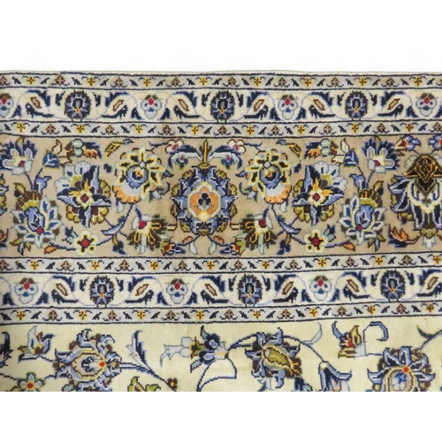 2004 - AN IVORY GROUND FINE KASHAN RUGwith all over floral/foliate patterned ground within beige flower hea... 