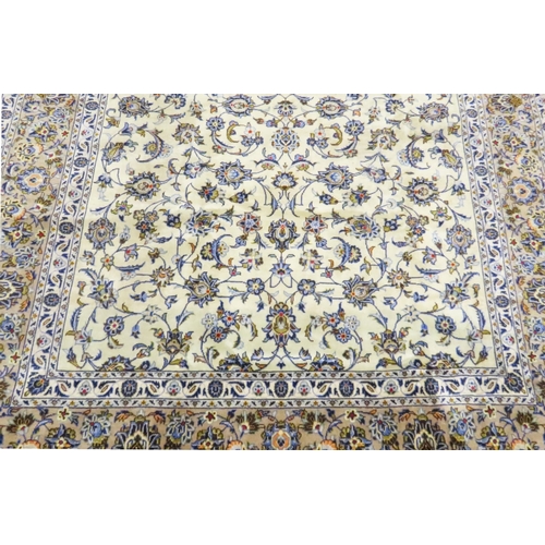 2004 - AN IVORY GROUND FINE KASHAN RUGwith all over floral/foliate patterned ground within beige flower hea... 
