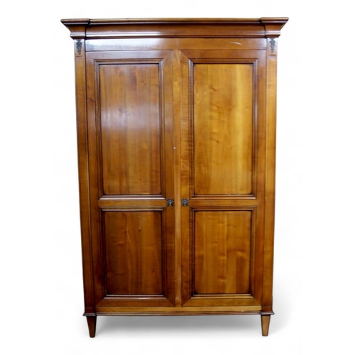 2032 - A 20TH CENTURY CHERRY WOOD AND SO TO BED TWO DOOR WARDROBEwith moulded corned over pair of panel war... 