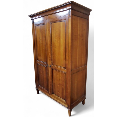 2032 - A 20TH CENTURY CHERRY WOOD AND SO TO BED TWO DOOR WARDROBEwith moulded corned over pair of panel war... 