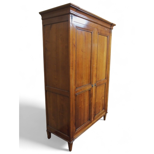2032 - A 20TH CENTURY CHERRY WOOD AND SO TO BED TWO DOOR WARDROBEwith moulded corned over pair of panel war... 