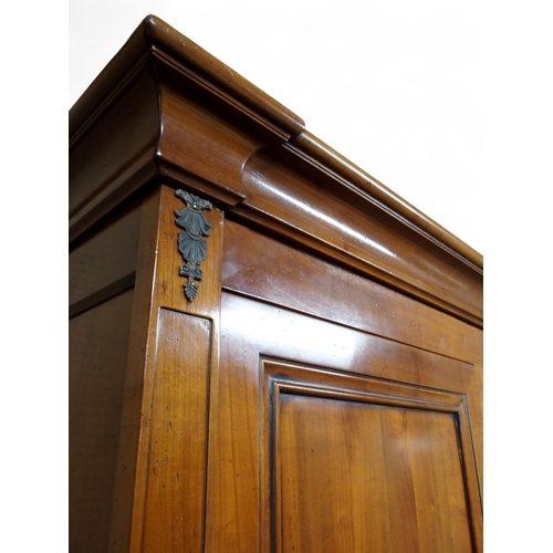 2032 - A 20TH CENTURY CHERRY WOOD AND SO TO BED TWO DOOR WARDROBEwith moulded corned over pair of panel war... 