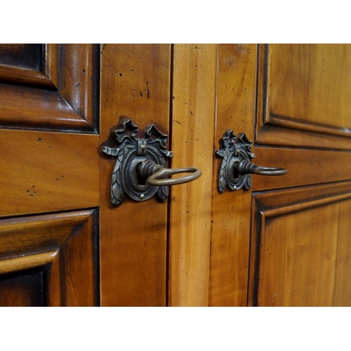 2032 - A 20TH CENTURY CHERRY WOOD AND SO TO BED TWO DOOR WARDROBEwith moulded corned over pair of panel war... 