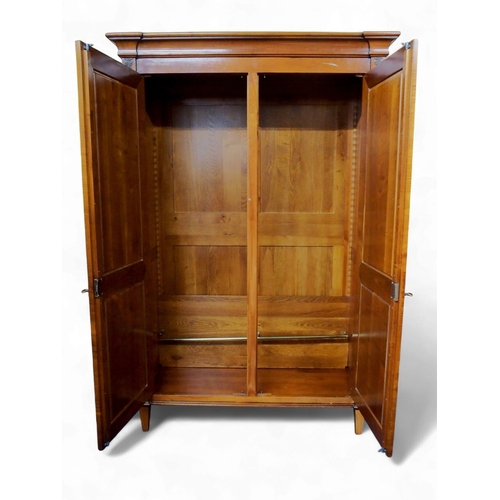 2032 - A 20TH CENTURY CHERRY WOOD AND SO TO BED TWO DOOR WARDROBEwith moulded corned over pair of panel war... 