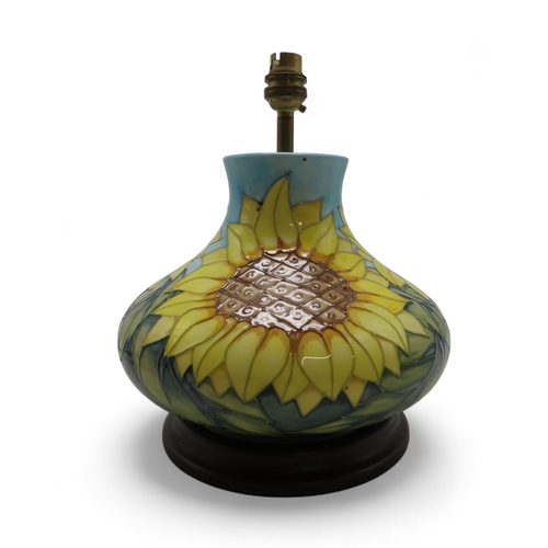2192 - A MOORCROFT SUNFLOWERS TABLE LAMPof squat baluster form, upon wooden base, 30cm high including fitti... 