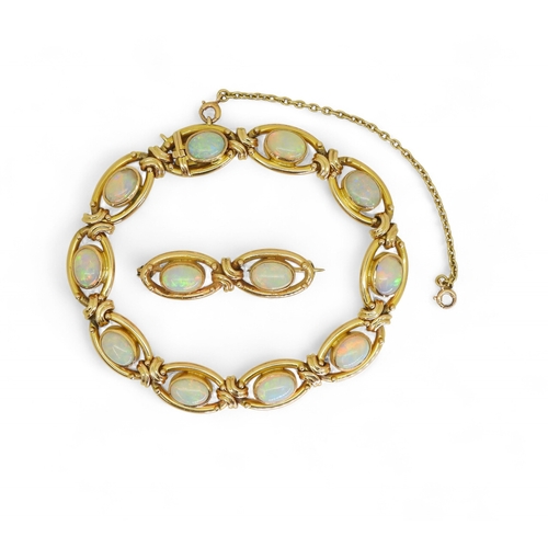 2733 - A 15CT GOLD OPAL BRACELETthe oval links are interspaced with gold knots, very lively opals, with ful... 