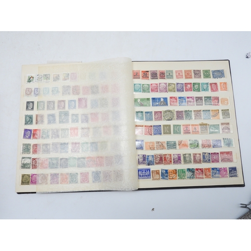 7130 - A worldwide stamp collection in four stock books together with an album of first day covers