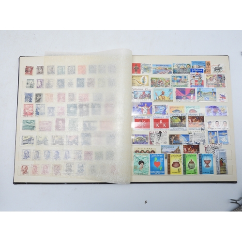 7130 - A worldwide stamp collection in four stock books together with an album of first day covers