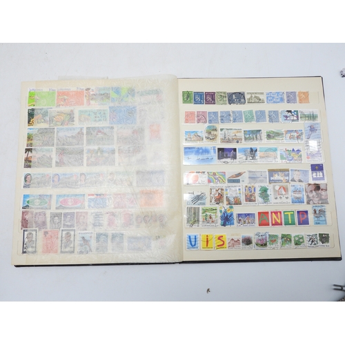 7130 - A worldwide stamp collection in four stock books together with an album of first day covers