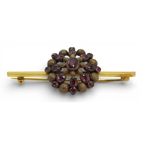 2706 - THREE VINTAGE BROOCHESa yellow metal bar brooch set with a blue glass gem, faintly stamped with a ha... 