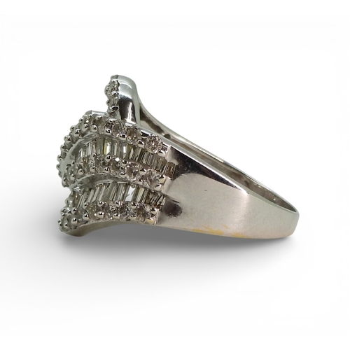 2711 - A DIAMOND DRESS RINGmade in 10k white gold and set with swirls of baguette and brilliant cut diamond... 