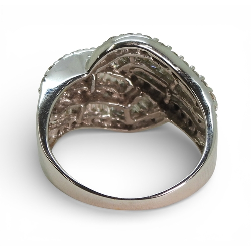 2711 - A DIAMOND DRESS RINGmade in 10k white gold and set with swirls of baguette and brilliant cut diamond... 