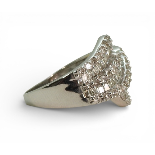 2711 - A DIAMOND DRESS RINGmade in 10k white gold and set with swirls of baguette and brilliant cut diamond... 