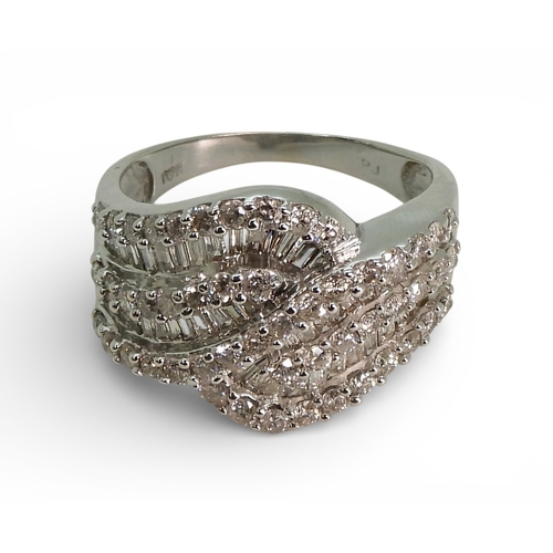 2711 - A DIAMOND DRESS RINGmade in 10k white gold and set with swirls of baguette and brilliant cut diamond... 