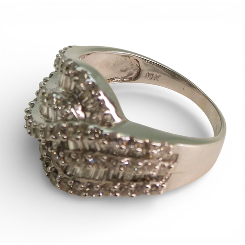 2711 - A DIAMOND DRESS RINGmade in 10k white gold and set with swirls of baguette and brilliant cut diamond... 