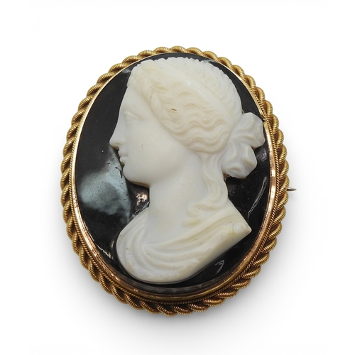 2719 - AN AGATE CAMEOfinely carved in brown,black and white banded agate, in a 15ct gold brooch mount, dime... 