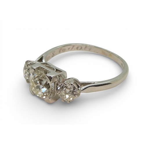 2720 - A THREE STONE DIAMOND RINGthe galleried mount is made in white metal, and set with three old cut dia... 