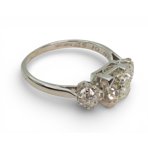 2720 - A THREE STONE DIAMOND RINGthe galleried mount is made in white metal, and set with three old cut dia... 