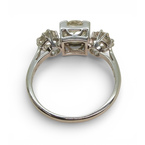 2720 - A THREE STONE DIAMOND RINGthe galleried mount is made in white metal, and set with three old cut dia... 