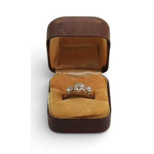 2720 - A THREE STONE DIAMOND RINGthe galleried mount is made in white metal, and set with three old cut dia... 