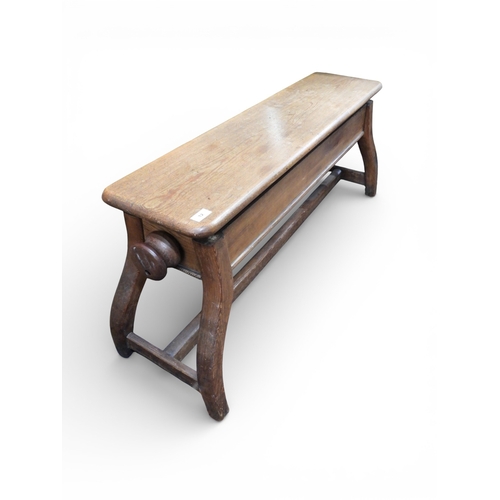 12 - An early 20th century beech adjustable piano bench on serpentine supports joined by H stretcher, 51c... 