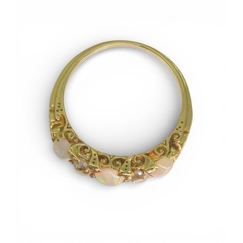 2733 - AN OPAL & DIAMOND RINGin a bright yellow metal decorative scroll mount. Lively opals interspaced... 