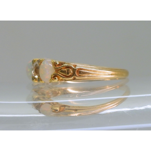 2733 - AN OPAL & DIAMOND RINGin a bright yellow metal decorative scroll mount. Lively opals interspaced... 