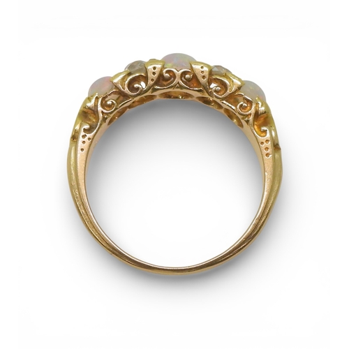 2733 - AN OPAL & DIAMOND RINGin a bright yellow metal decorative scroll mount. Lively opals interspaced... 