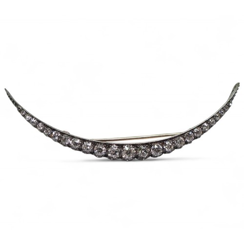 2754 - A VICTORIAN DIAMOND CRESCENT MOON BROOCHthe yellow and white metal galleried mount is set with estim... 