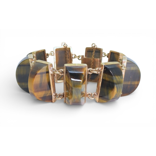 2748 - A BLUE & GOLDEN TIGERSEYE BRACELETof abstract form, set with semi circular facet cut tigerseye g... 