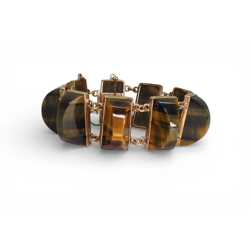 2748 - A BLUE & GOLDEN TIGERSEYE BRACELETof abstract form, set with semi circular facet cut tigerseye g... 
