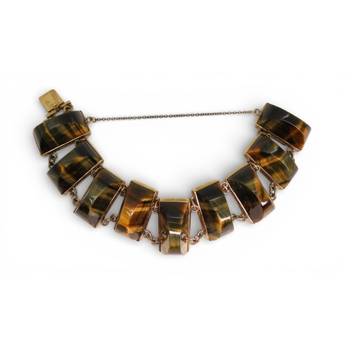 2748 - A BLUE & GOLDEN TIGERSEYE BRACELETof abstract form, set with semi circular facet cut tigerseye g... 