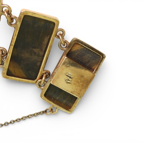 2748 - A BLUE & GOLDEN TIGERSEYE BRACELETof abstract form, set with semi circular facet cut tigerseye g... 