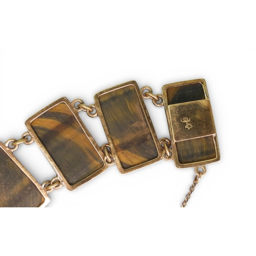 2748 - A BLUE & GOLDEN TIGERSEYE BRACELETof abstract form, set with semi circular facet cut tigerseye g... 