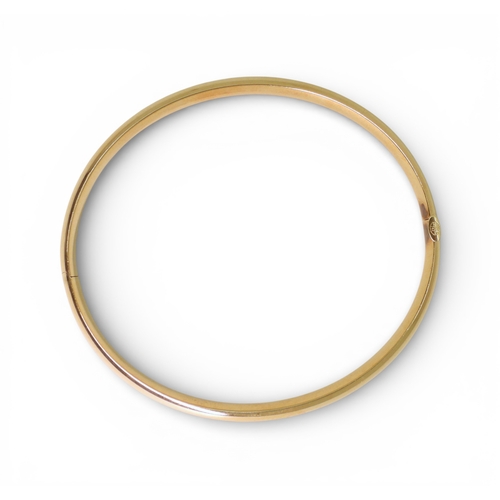 2751 - A CLASSIC PLAIN GOLD BANGLEmade in 14k gold, with gentle domed interior and exterior, the tongue of ... 
